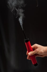 Person Holding Red Smoking Stick